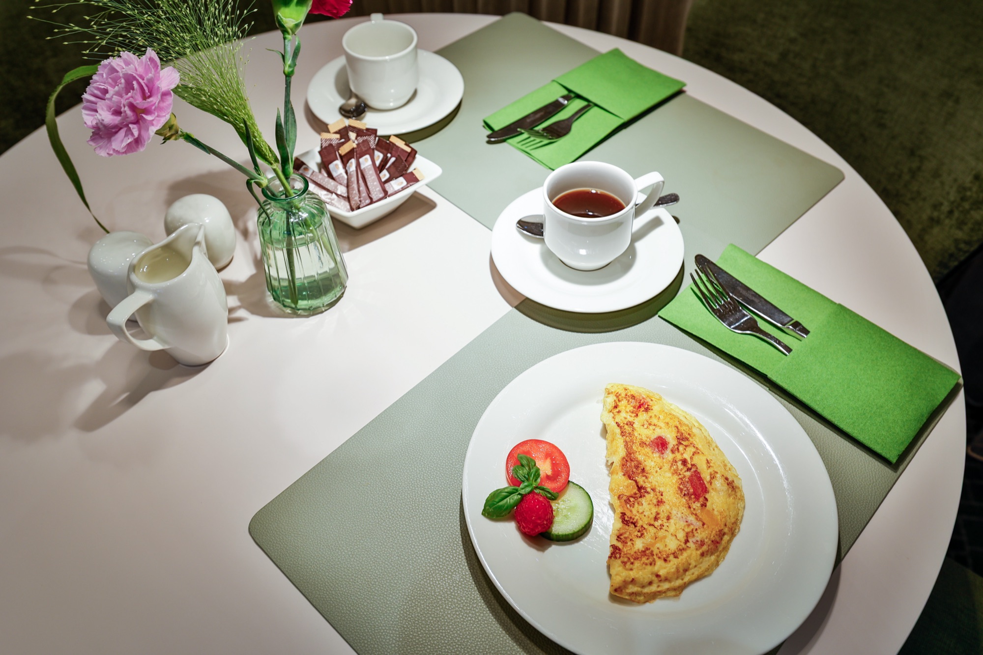 Gedeckter Frühstückstisch mit Omelett und Kaffee