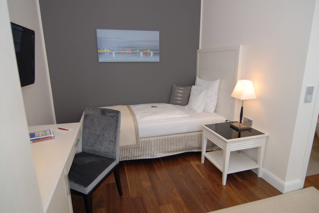 Einzelzimmer Maat mit Boxspringbett und Schreibtisch