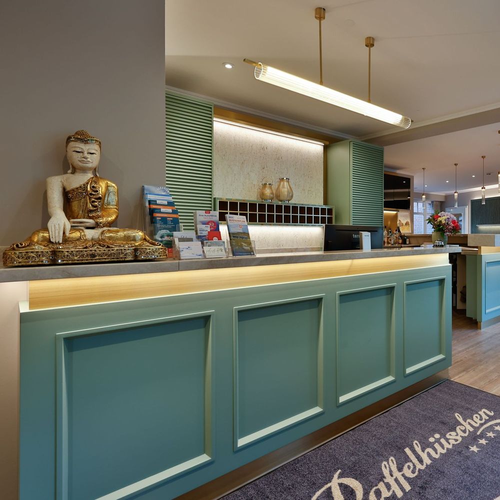 Rezeption im Sylthotel Raffelhüschen mit Logo-Teppich am Eingang