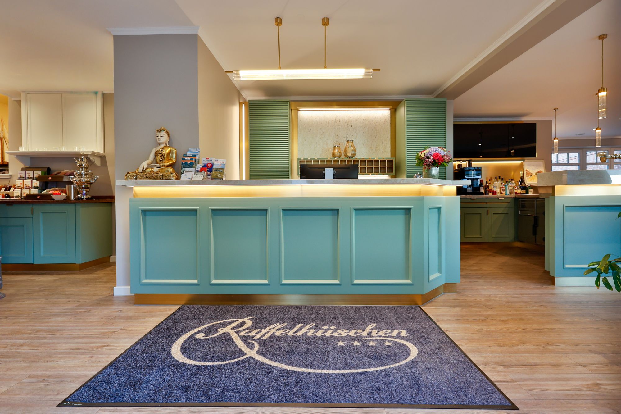 Rezeption im Sylthotel Raffelhüschen mit Logo-Teppich am Eingang